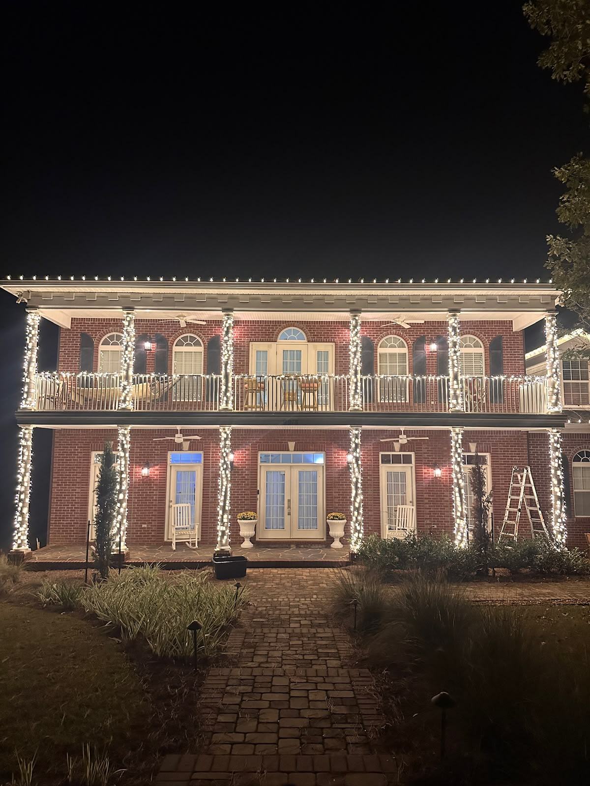 Wrapped columns and warm white roofline on a two-story brick home