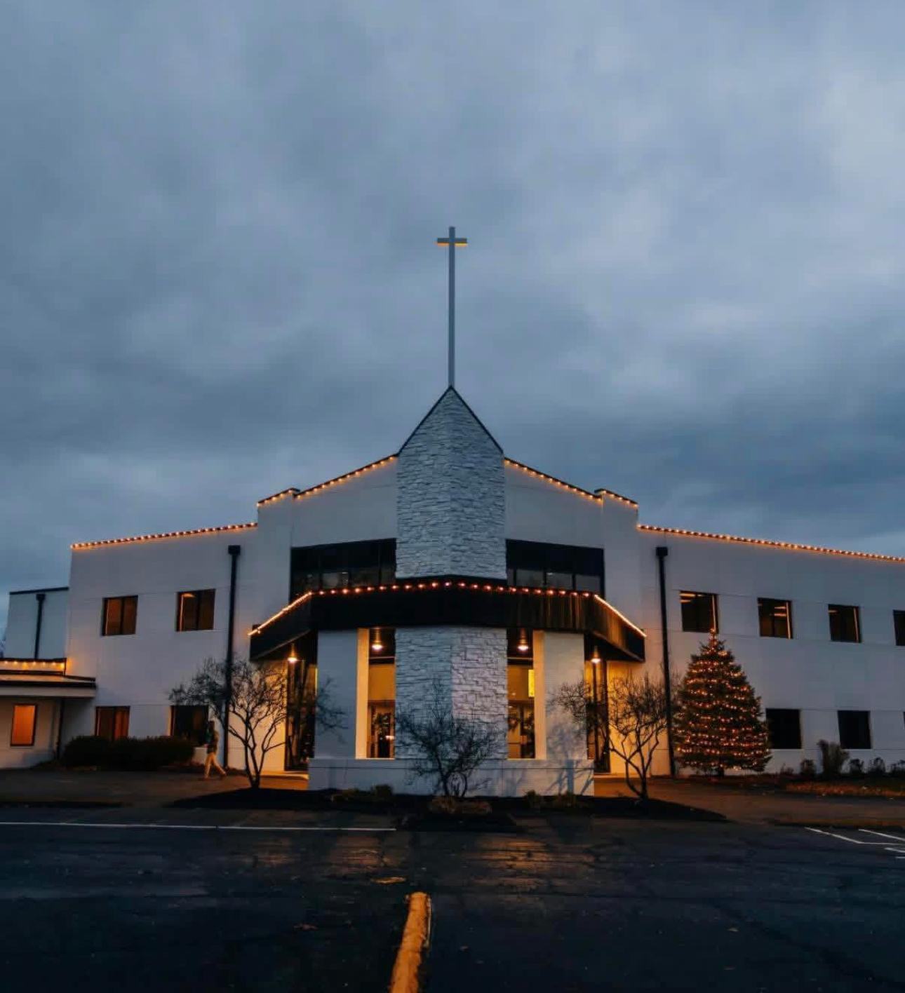 Warm white roofline lighting on a commercial building with a lit tree